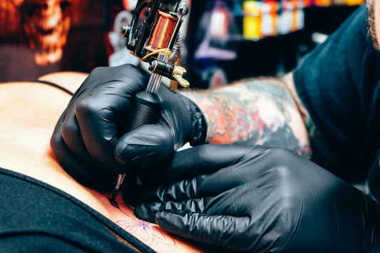 A man with a tattoo on his arm holding a gun